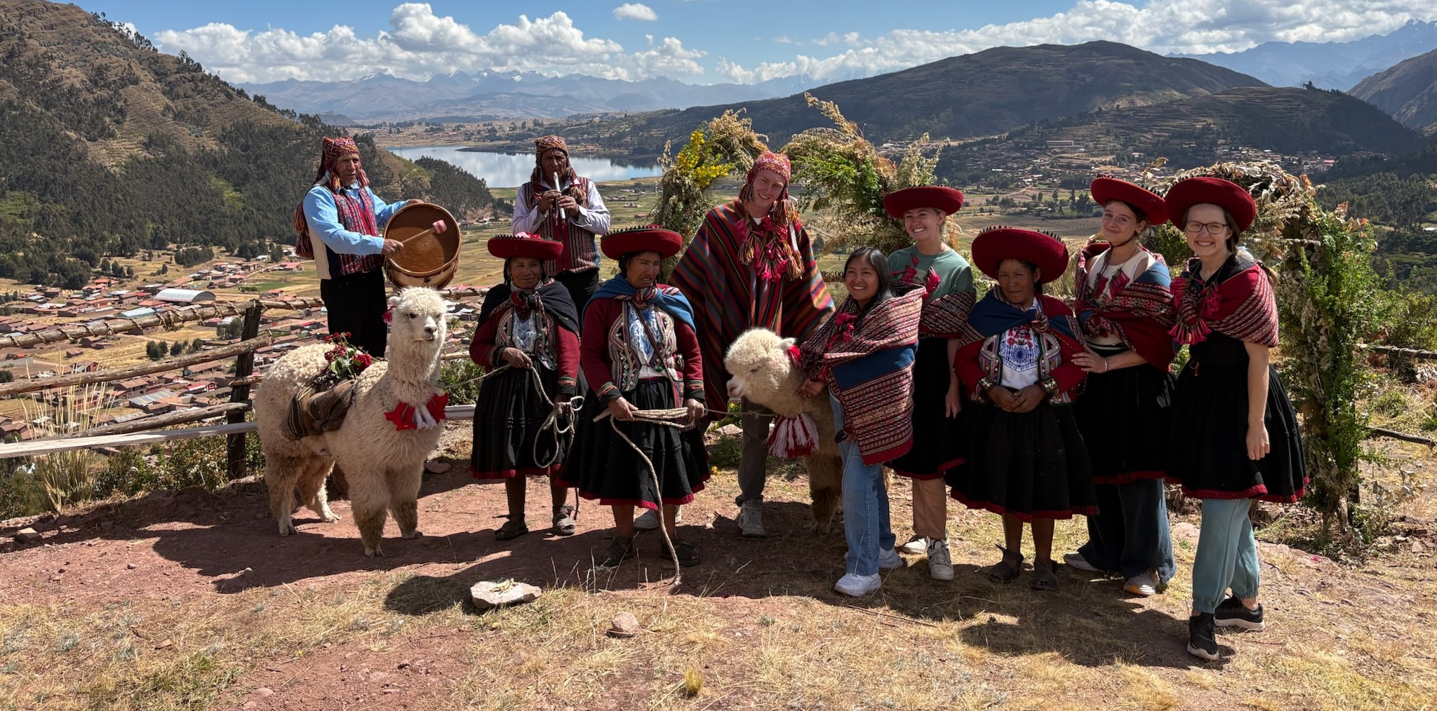 Qosqo Away guests in traditional Quechua dress with alpacas, overlooking the Sacred Valley near Cusco, Peru