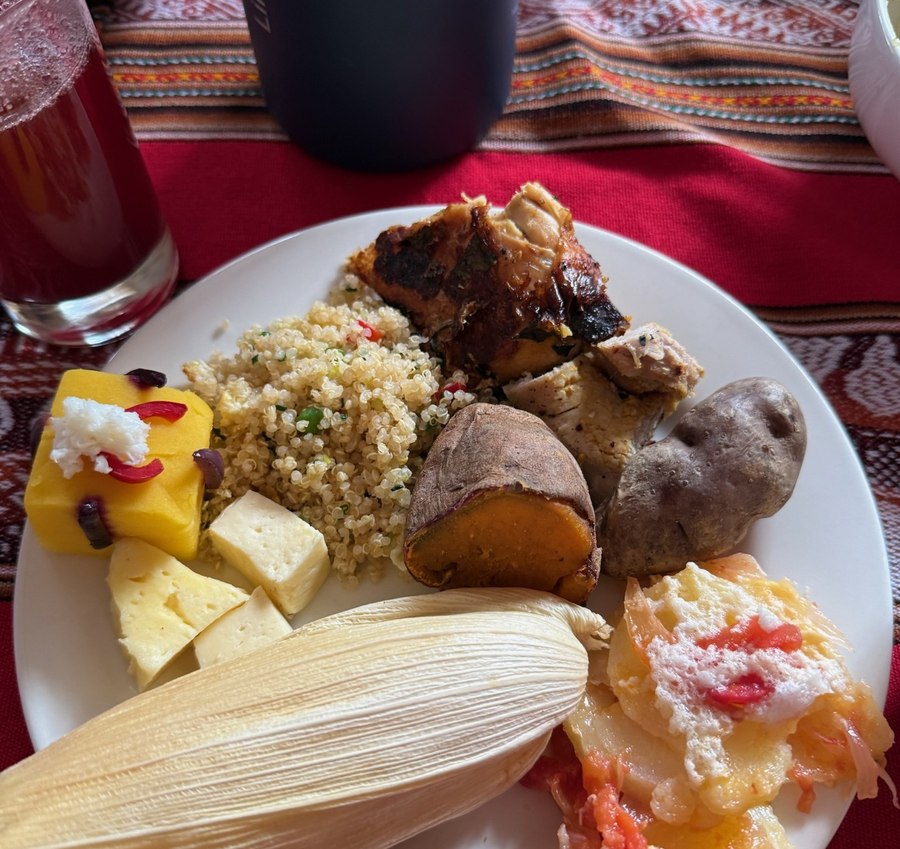 Traditional Andean meal plate with chicken, quinoa, sweet potato, cheese, and tamale
